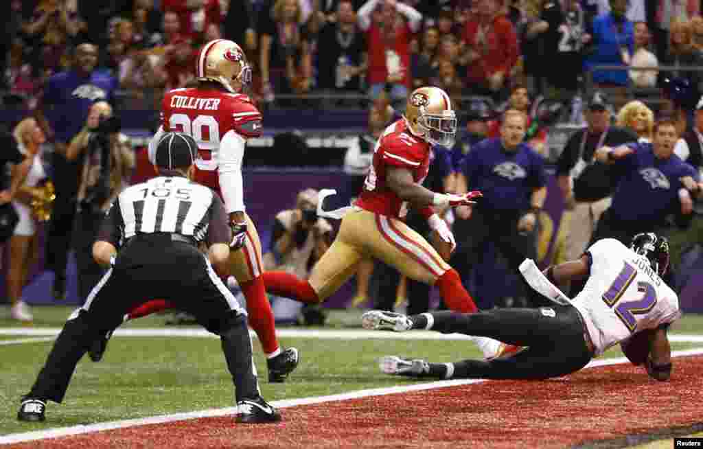 Baltimore Ravens wide receiver Jacoby Jones (12) dives for a touchdown past San Francisco 49ers cornerback Tarell Brown during the second quarter in the NFL Super Bowl XLVII football game in New Orleans, Louisiana, February 3, 2013.